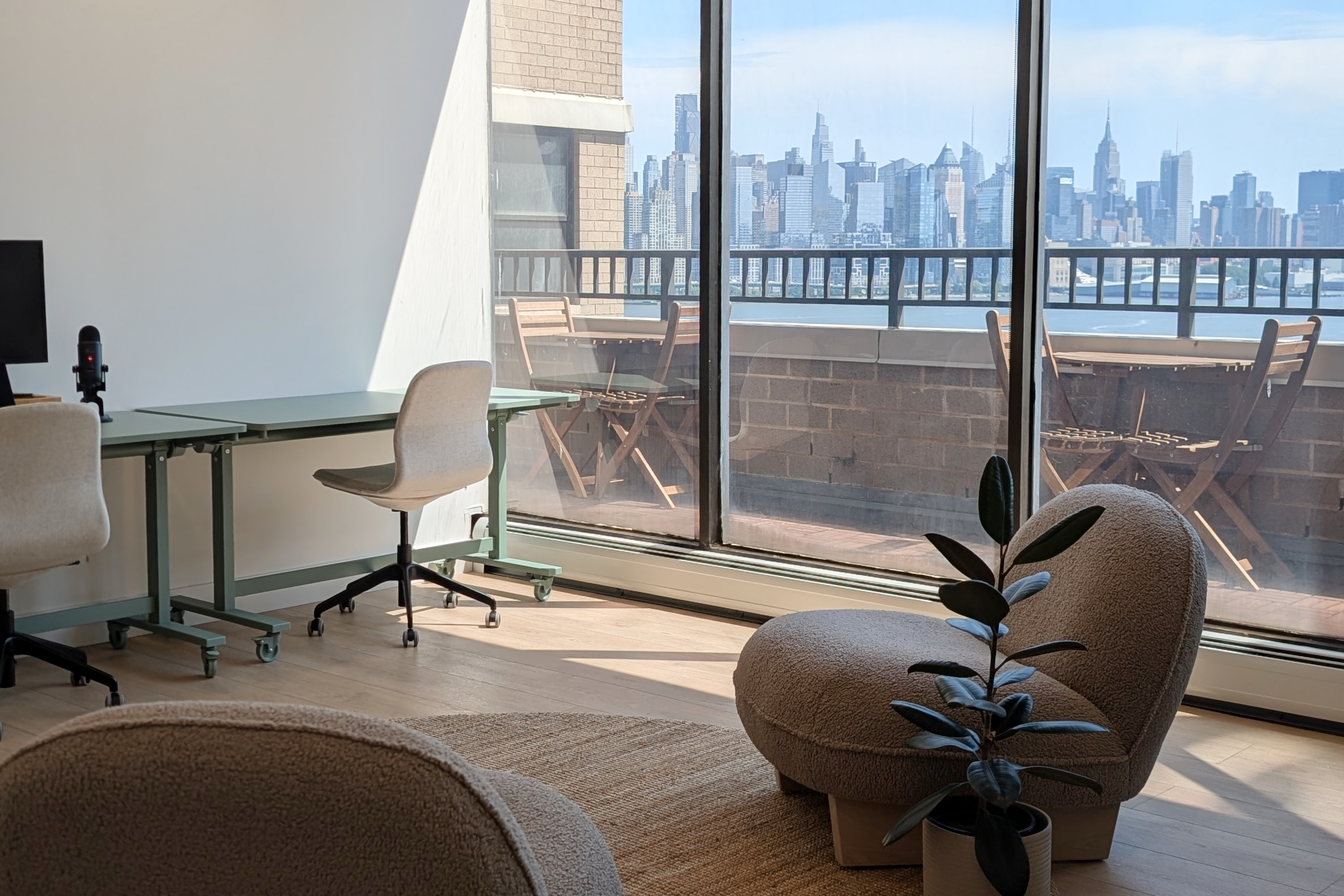 HudsonDesk lounge with desks and an outdoor terrace looking out at the Manhattan skyline